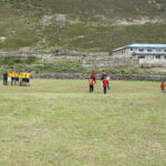 altitude sickness Nepal trekking — porters and trekkers playing soccer at 14,000 feet in the Himalayas